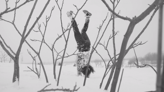 Marie-Eve Dicaire does a handstand in snow, surrounded by tree branches